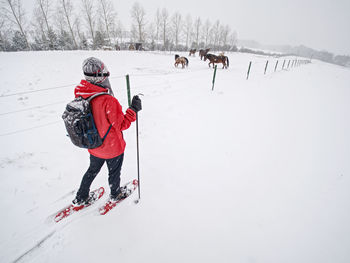 Rear view of men on snow covered field