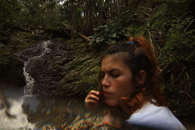 Double exposure of woman and stream at forest