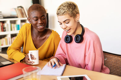 Smiling lesbian couple discussing while working at home