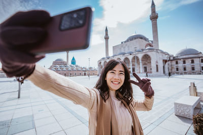 Portrait of young woman standing in city