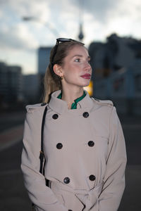 Portrait of young woman looking away while standing outdoors