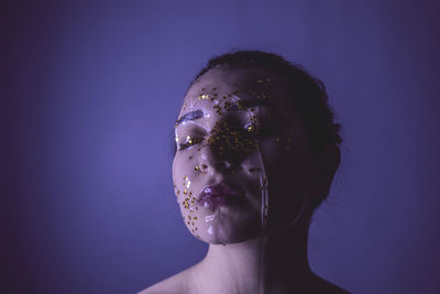 Close-up of woman with water and star shape decoration against blue background