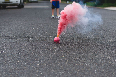 Red smoke emitting from firework on street