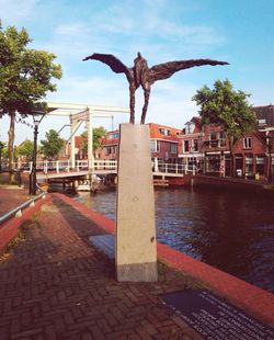 Statue by trees against sky in city