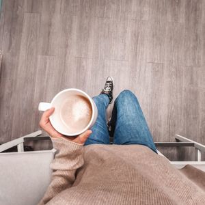 Low section of woman with coffee cup