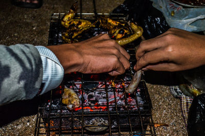 Midsection of man preparing food on barbecue grill