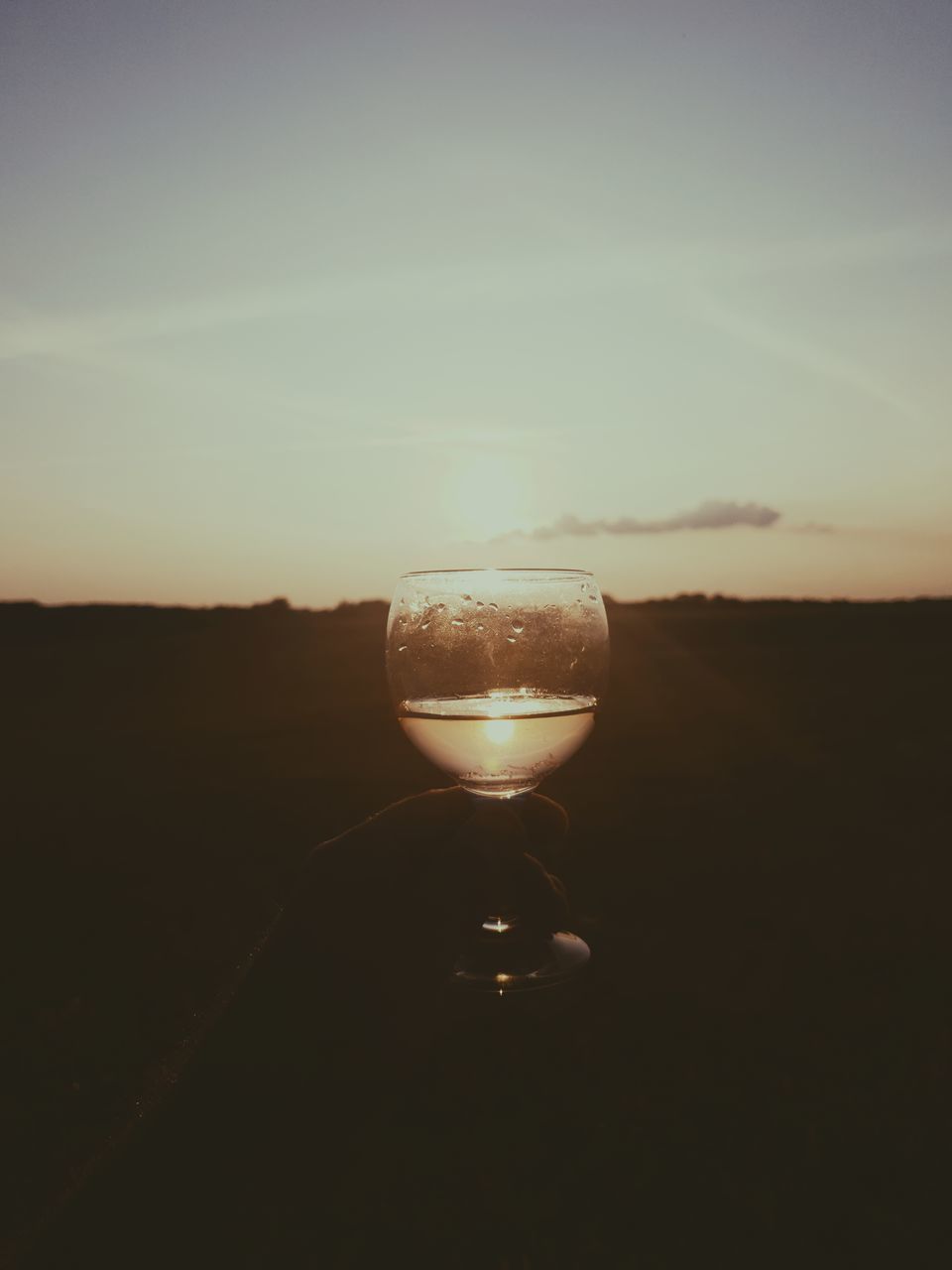 CLOSE-UP OF BEER GLASS AGAINST SUNSET SKY