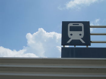 Information sign against sky