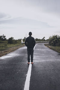 Rear view of man standing on road