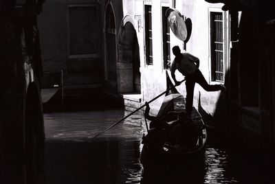 Silhouette man on boat in canal