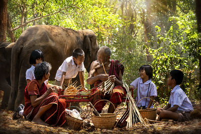 Group of people sitting by plants