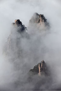 Scenic view of rocky mountains during foggy weather