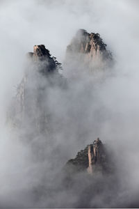 People on rock against sky