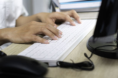 Midsection of man using laptop on table