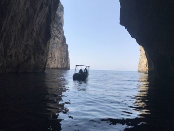 Scenic view of rock formation in sea against sky