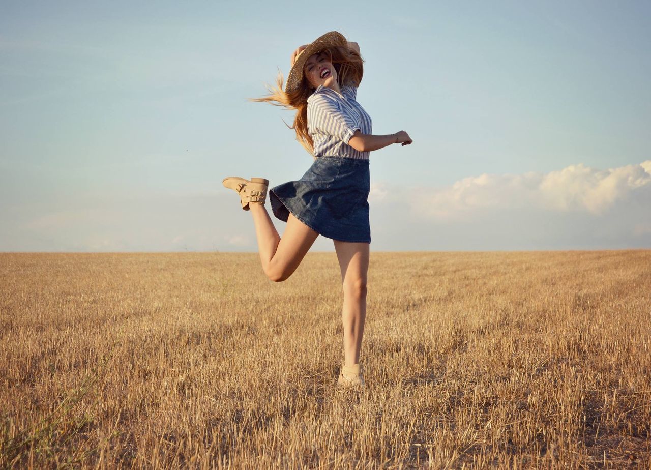 full length, field, sky, lifestyles, leisure activity, grass, casual clothing, standing, landscape, young adult, tranquil scene, rear view, tranquility, nature, young women, freedom, person, scenics