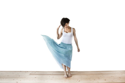 Full length of woman standing against white background