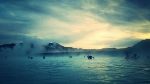 People at blue lagoon against sky