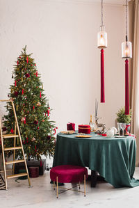 Stylish luxurious interior of the dining room with a christmas tree. a chair near the round table 