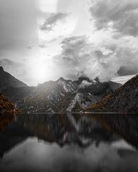 Scenic view of lake by mountains against sky