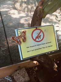 High angle view of information sign on tree trunk