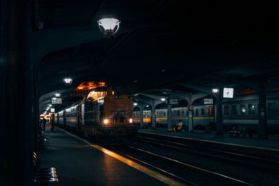 Train at railroad station against sky at night