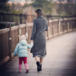 Rear view of women walking on footpath