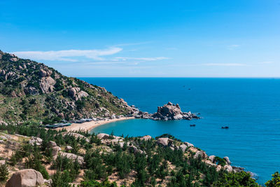 View of rock mountain by sea against sky