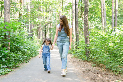 Full length of mother and daughter in forest