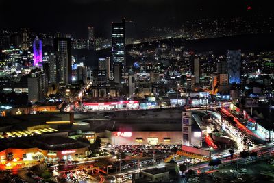 High angle view of illuminated cityscape against sky at night