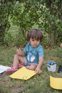 Cute baby boy sitting on slide at park