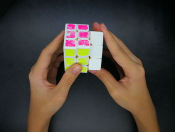 Midsection of woman holding paper against black background