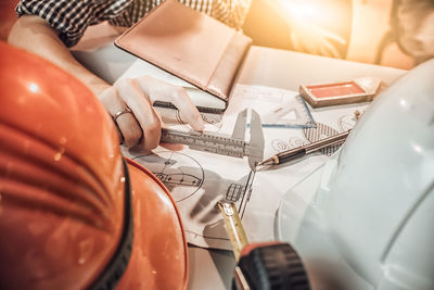 Close-up of architect drawing blueprint at desk in office