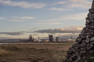 Factory on field against sky