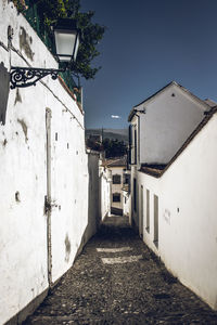 Footpath amidst buildings against sky