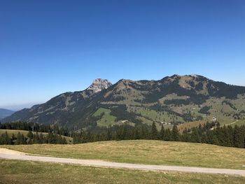 Scenic view of mountains against clear blue sky