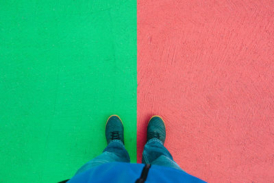 Low section of person standing against green wall