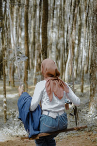 Side view of woman standing in forest