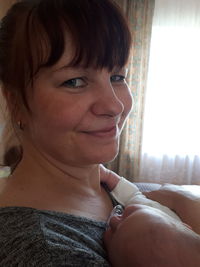 Close-up portrait of smiling woman at home