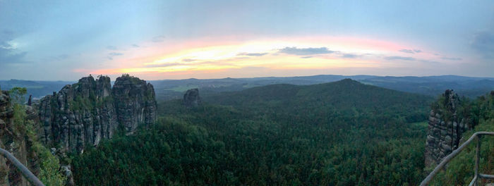 Panoramic shot of green landscape against sky during sunset