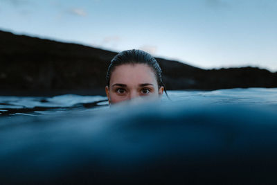 Portrait of woman swimming in sea against sky