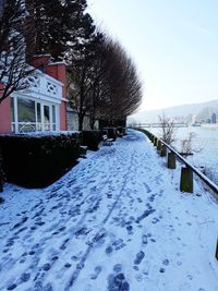 Snow covered houses and trees against clear sky