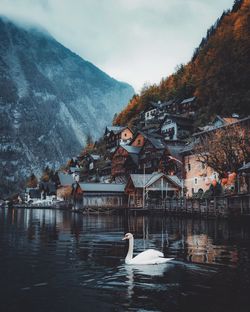 View of buildings by lake against mountain