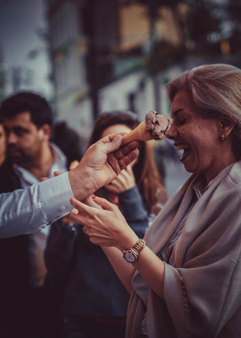 SIDE VIEW OF A MAN HOLDING WOMAN EATING