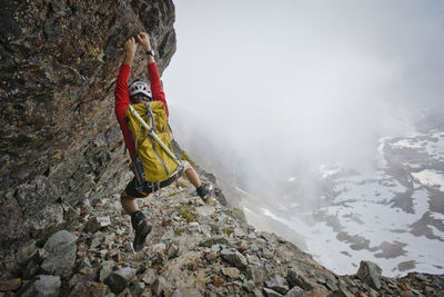 Hiker with backpack climbing mountain