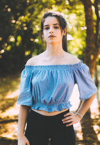 Portrait of young woman standing at park