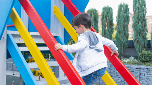 Side view of boy playing on slide at playground