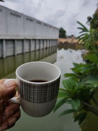 Close-up of hand holding coffee cup