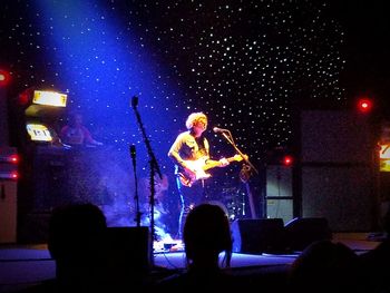 Man at music concert against sky at night