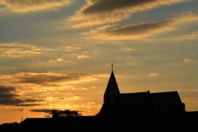 Low angle view of silhouette building against sky during sunset